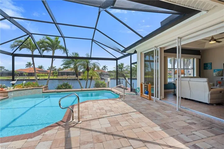 Pool featuring a water view, a patio area, and a lanai