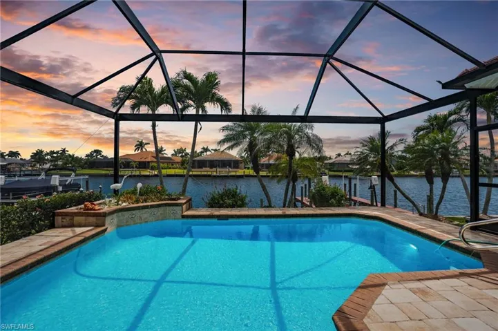 Outdoor pool with a lanai, a water view, and a patio area