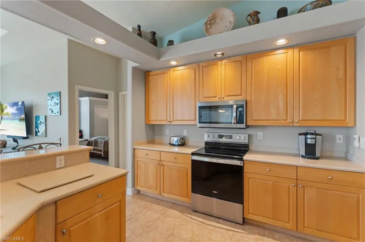 Kitchen with light tile patterned floors, light countertops, light brown cabinets, stainless steel appliances, and recessed lighting