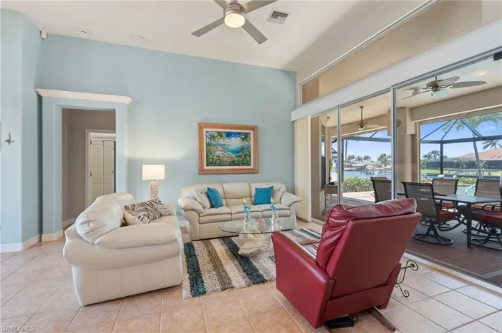 Living room featuring tile patterned flooring, a ceiling fan, baseboards, and visible vents
