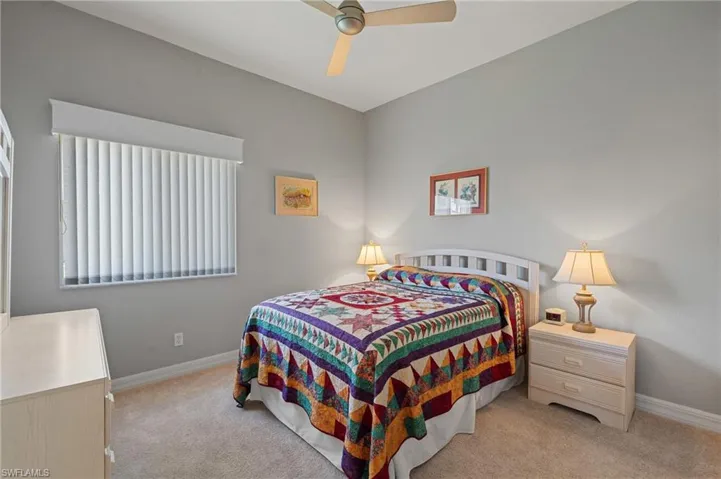 Bedroom with baseboards, ceiling fan, and light carpet