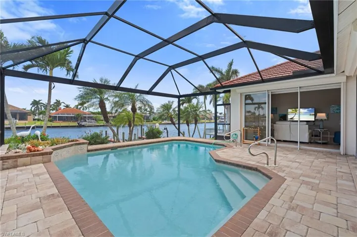 Outdoor pool featuring a water view and a patio area