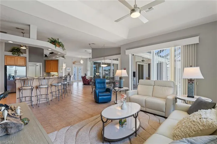 Living room featuring visible vents, a ceiling fan, and light tile patterned flooring