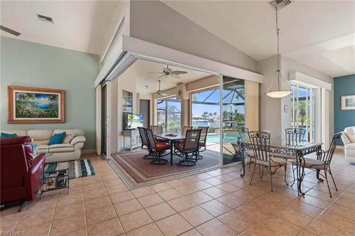 Dining space with a sunroom, ceiling fan, visible vents, and light tile patterned floors