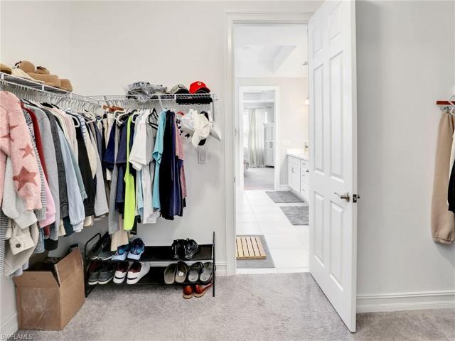 Primary Walk-in closet with door to laundry room.