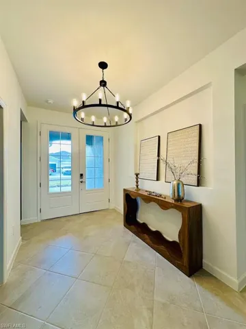 Doorway to outside featuring french doors, a chandelier, and tile patterned flooring