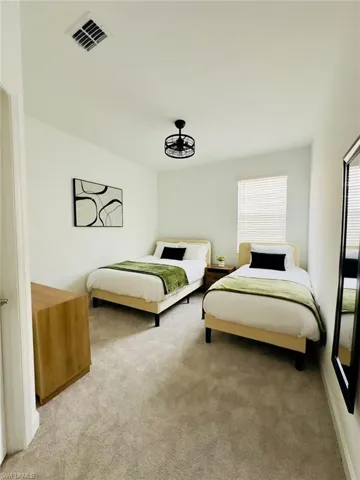 Bedroom featuring light carpet