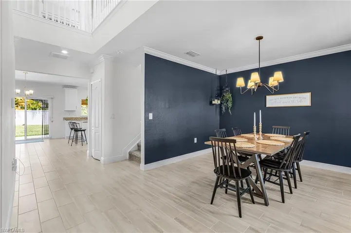 Dining area featuring a dark accent wall and a multi-arm chandelier