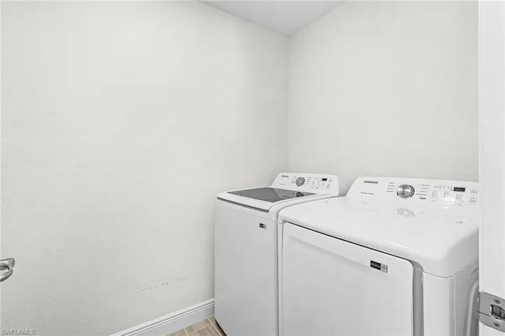 Dedicated laundry area featuring a white top-load washing machine and a white front-load dryer