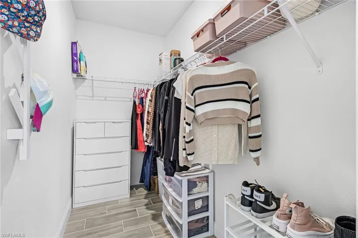 Walking Closet bedroom 5 featuring a corner configuration of wire shelving and hanging rods