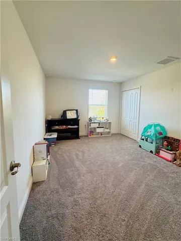 3rd Carpeted bedroom, window covering, and walking closet.