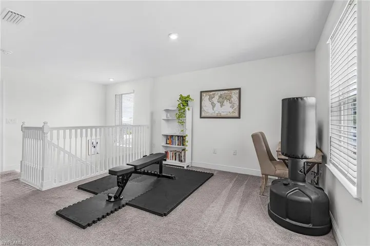 Open loft space featuring light gray carpet, and white walls