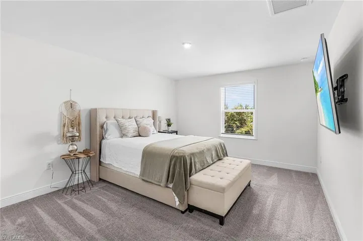 Carpeted bedroom 2 featuring a single window with blinds, recessed lighting, and a wall-mounted television bracket