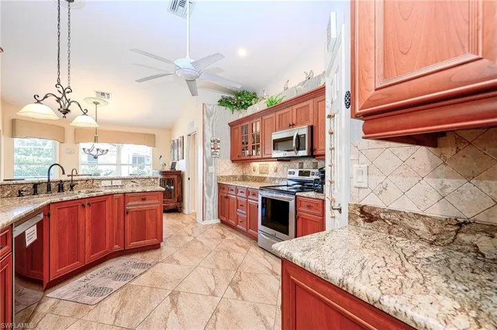 Kitchen with stainless steel appliances, a sink, vaulted ceiling, visible vents, and decorative backsplash