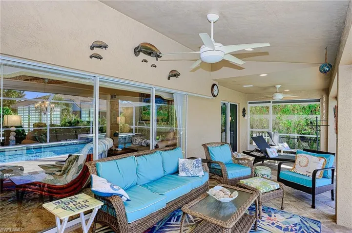 Sunroom featuring an outdoor living space and ceiling fan with notable chandelier