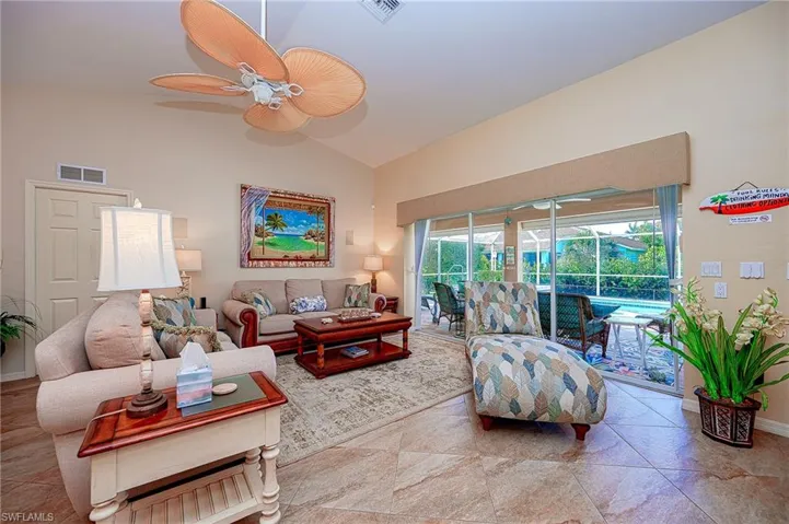 Living area featuring high vaulted ceiling, ceiling fan, baseboards, and visible vents