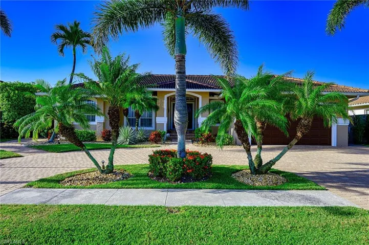 View of front of house with stucco siding, a tile roof, and decorative driveway