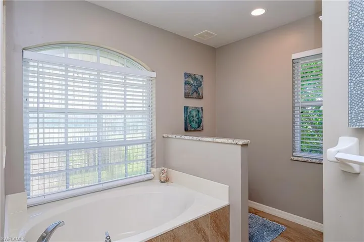 Full bath with a bath, visible vents, and plenty of natural light
