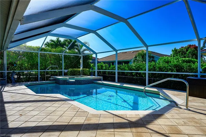 View of pool featuring a lanai, a patio area, and a pool with connected hot tub