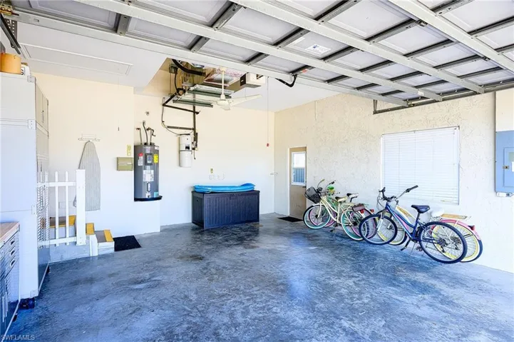 Garage featuring electric panel and water heater