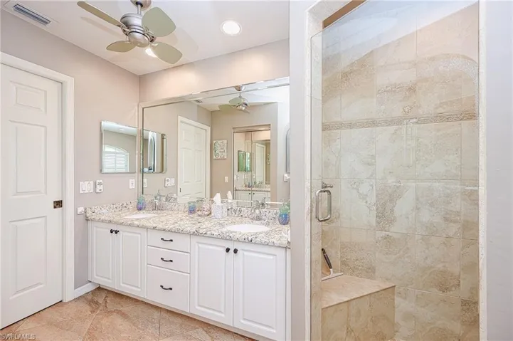 Bathroom featuring visible vents, a sink, a shower stall, and ceiling fan