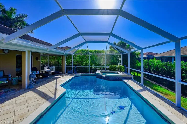 View of pool featuring a lanai, a patio, and a pool with connected hot tub