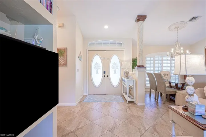 Foyer entrance featuring baseboards, french doors, visible vents, and an inviting chandelier
