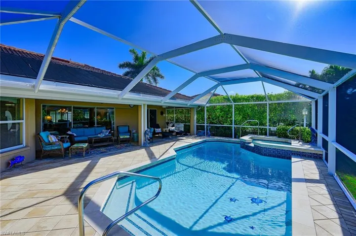 View of swimming pool with outdoor lounge area, a pool with connected hot tub, a lanai, and a patio