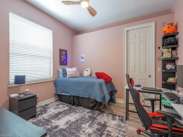 Wood-finish flooring, ceiling fan with integrated lighting, window with horizontal blinds