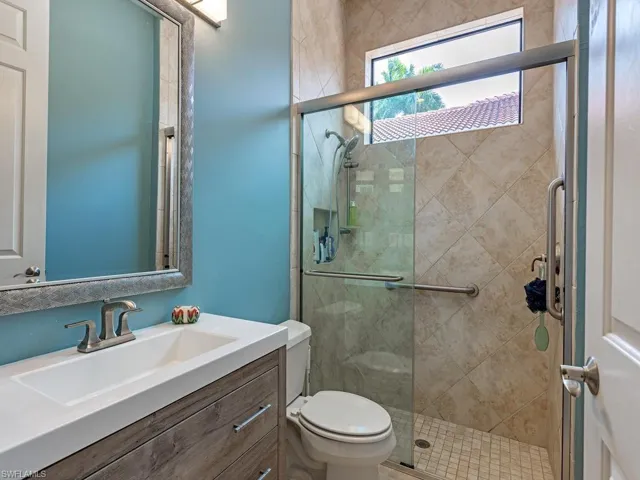 Sleek vanity with integrated sink, wood-finish cabinetry, and brushed nickel fixtures