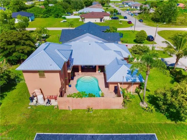 Aerial view of property and surrounding area featuring a pool area