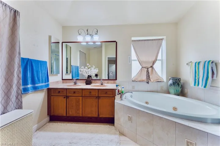 Bathroom featuring a whirlpool tub and double vanity