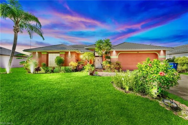 Ranch-style home with a garage, a yard, a metal roof, and driveway