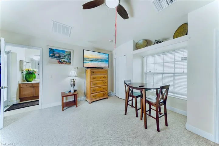 Dining room with carpet flooring, ceiling fan, and lofted ceiling