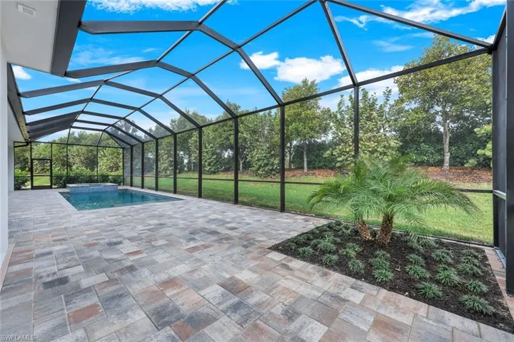 View of pool featuring a patio and glass enclosure