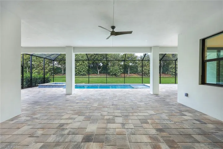 View of pool with an in ground hot tub, a lanai, ceiling fan, and a patio