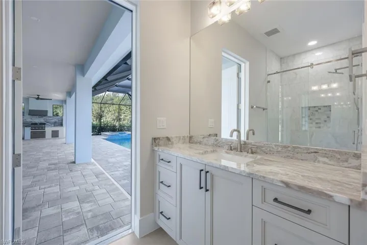 Bathroom featuring a shower with door and vanity