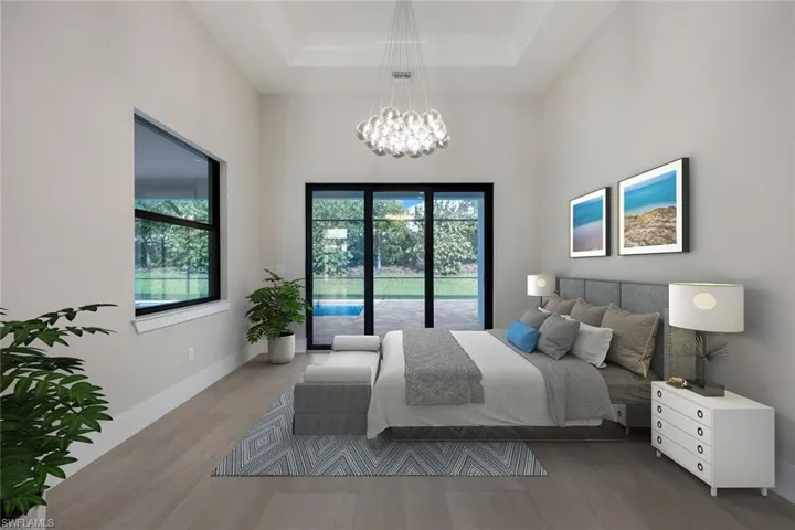 Virtually Staged Photo. Bedroom featuring baseboards, a raised ceiling, wood finished floors, and multiple windows