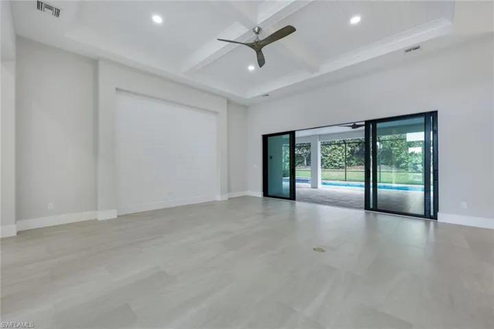 Spare room featuring coffered ceiling, ceiling fan, and beamed ceiling