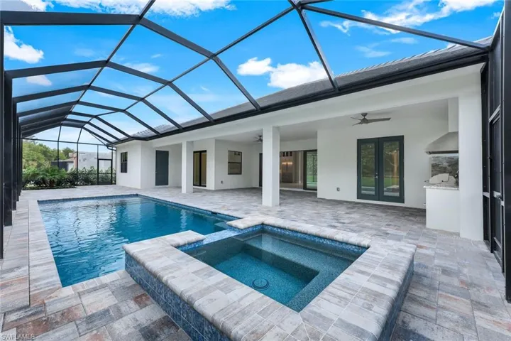 View of swimming pool featuring an in ground hot tub, a lanai, ceiling fan, and a patio