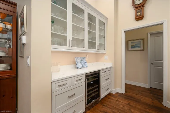 Kitchen bar area with beverage cooler and glass cabinet doors