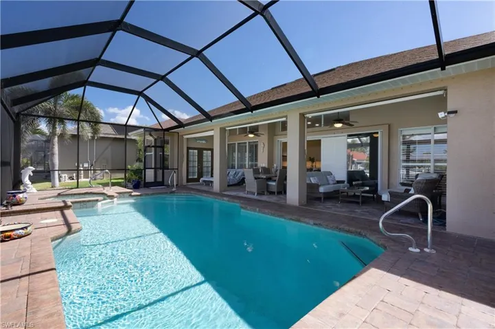 View of swimming pool with screen enclosure and large covered patio area