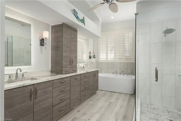 Bathroom with a large dual sink vanity and Quartz counter tops, deep soaking tub and glass shower