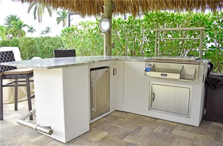View of patio with outdoor wet bar and area for grilling
