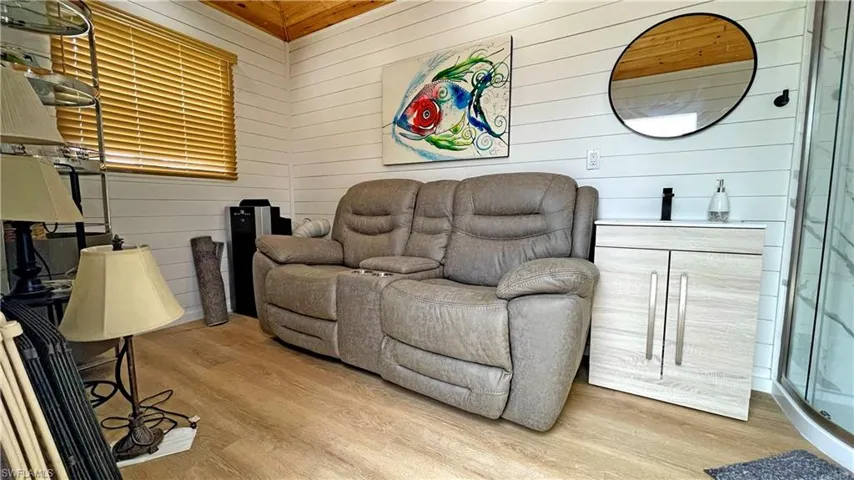 Sitting room featuring wood walls and light wood-style flooring