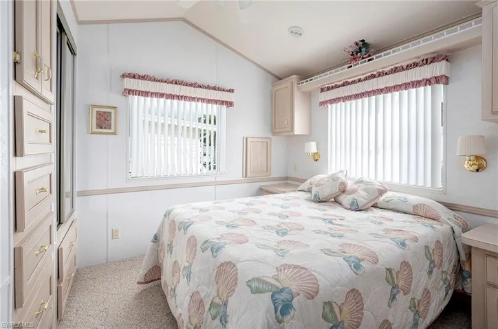 Carpeted bedroom with vaulted ceiling and ceiling fan