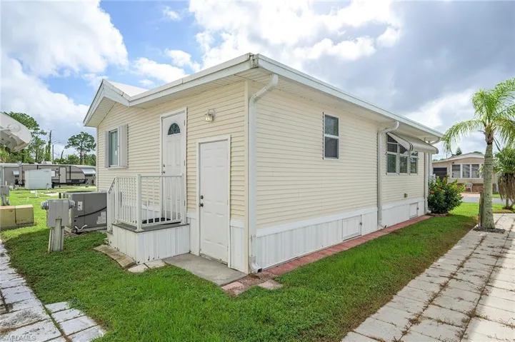 View of property exterior featuring a lawn