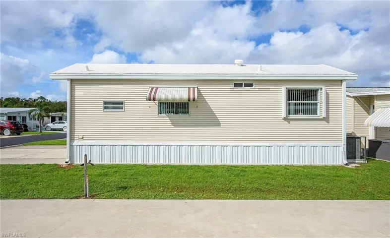 View of side of property featuring a lawn