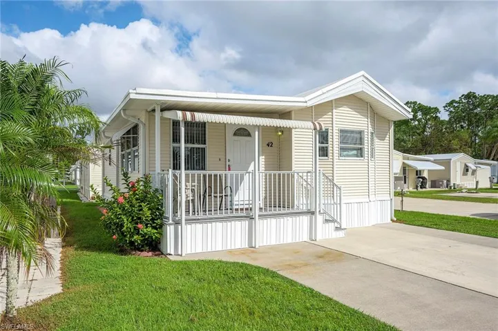 Manufactured / mobile home with a front lawn and covered porch