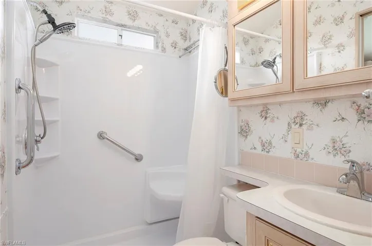 Bathroom with walk in shower, vanity, and toilet